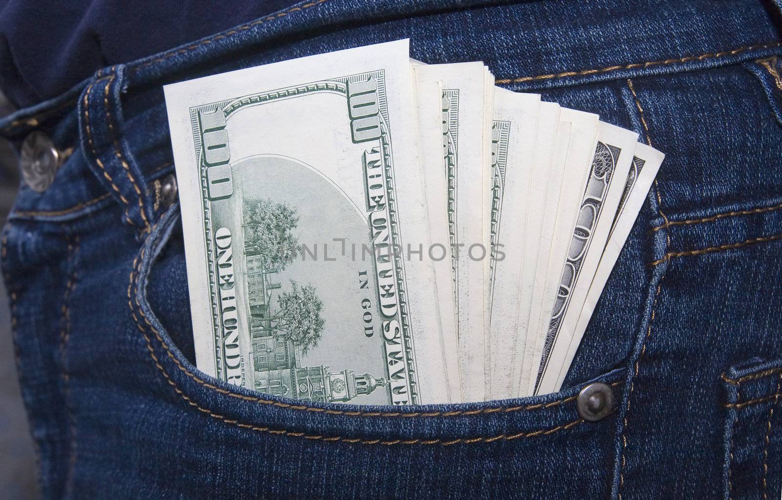 Bundle of dollars in a jeans rear pocket