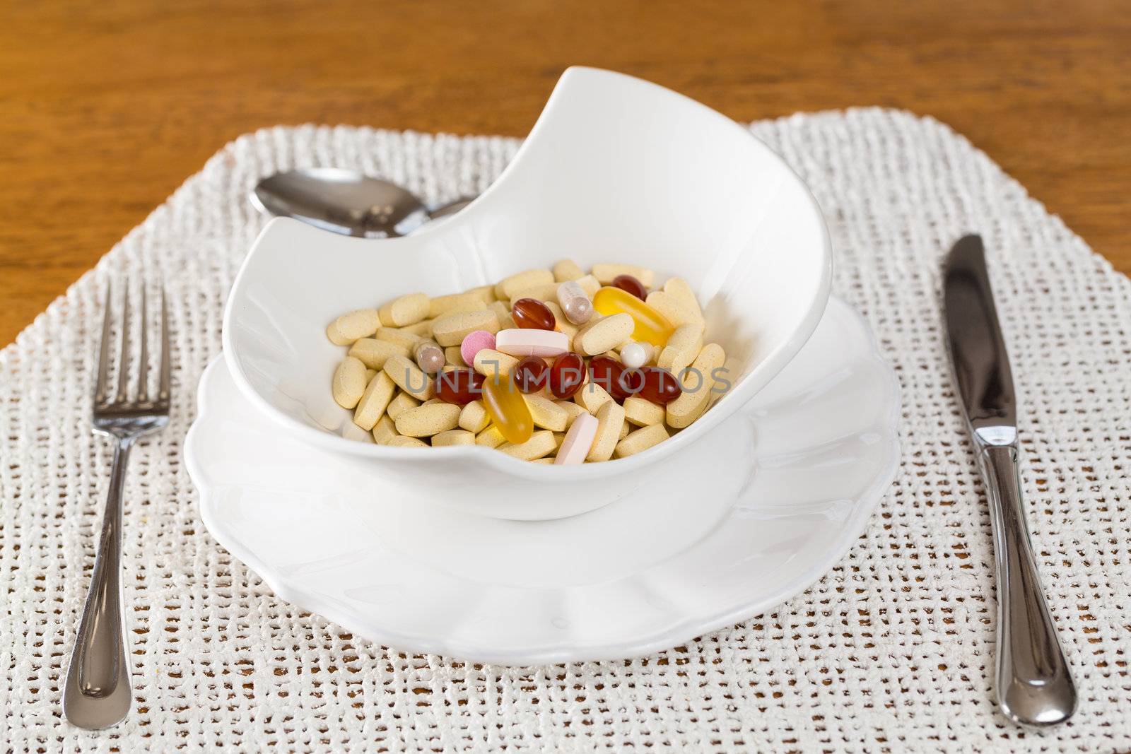 Vitamins in bowl of tablets for breakfast in kitchen