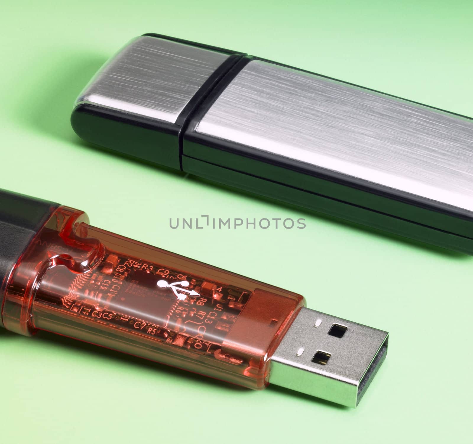 studio photography of 2 USB sticks in green back