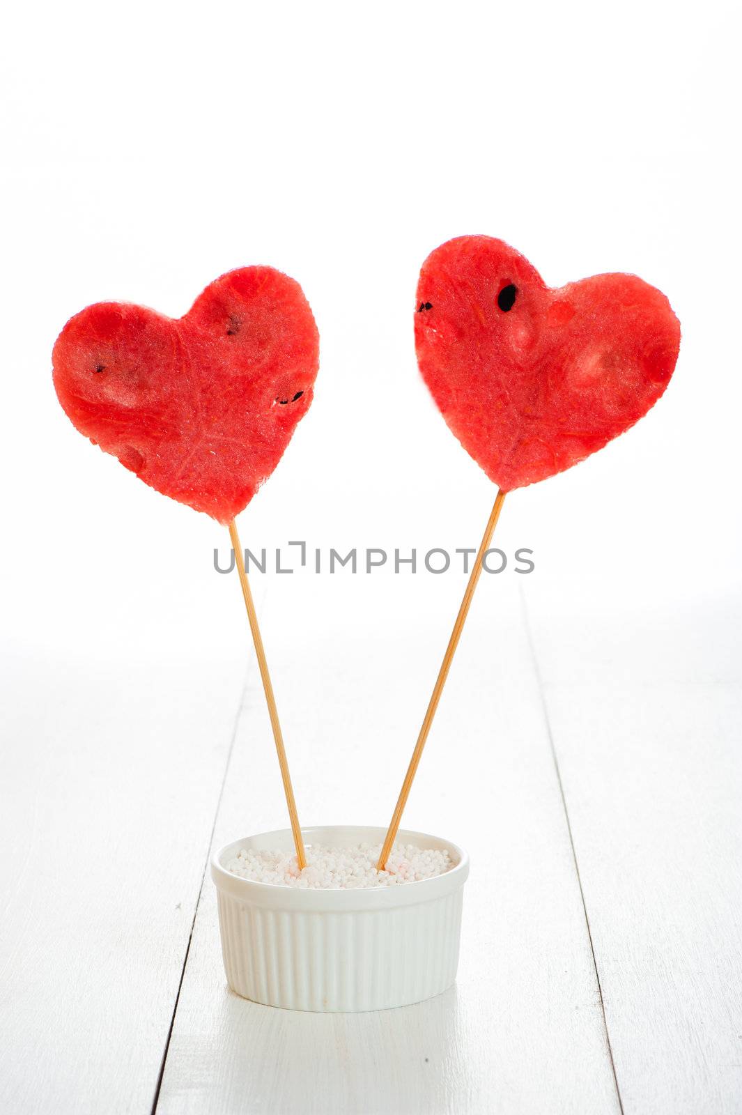 two watermelon heart as lollipop on white background as a studio shot