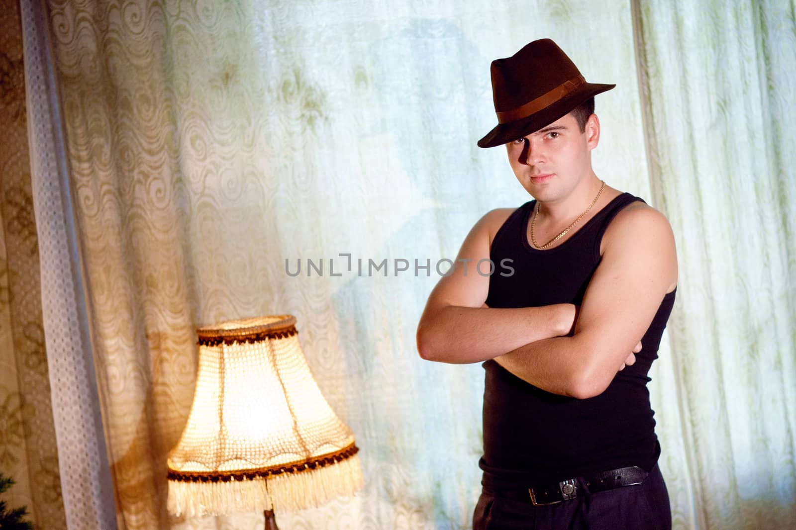 athletic young man in a hat at home