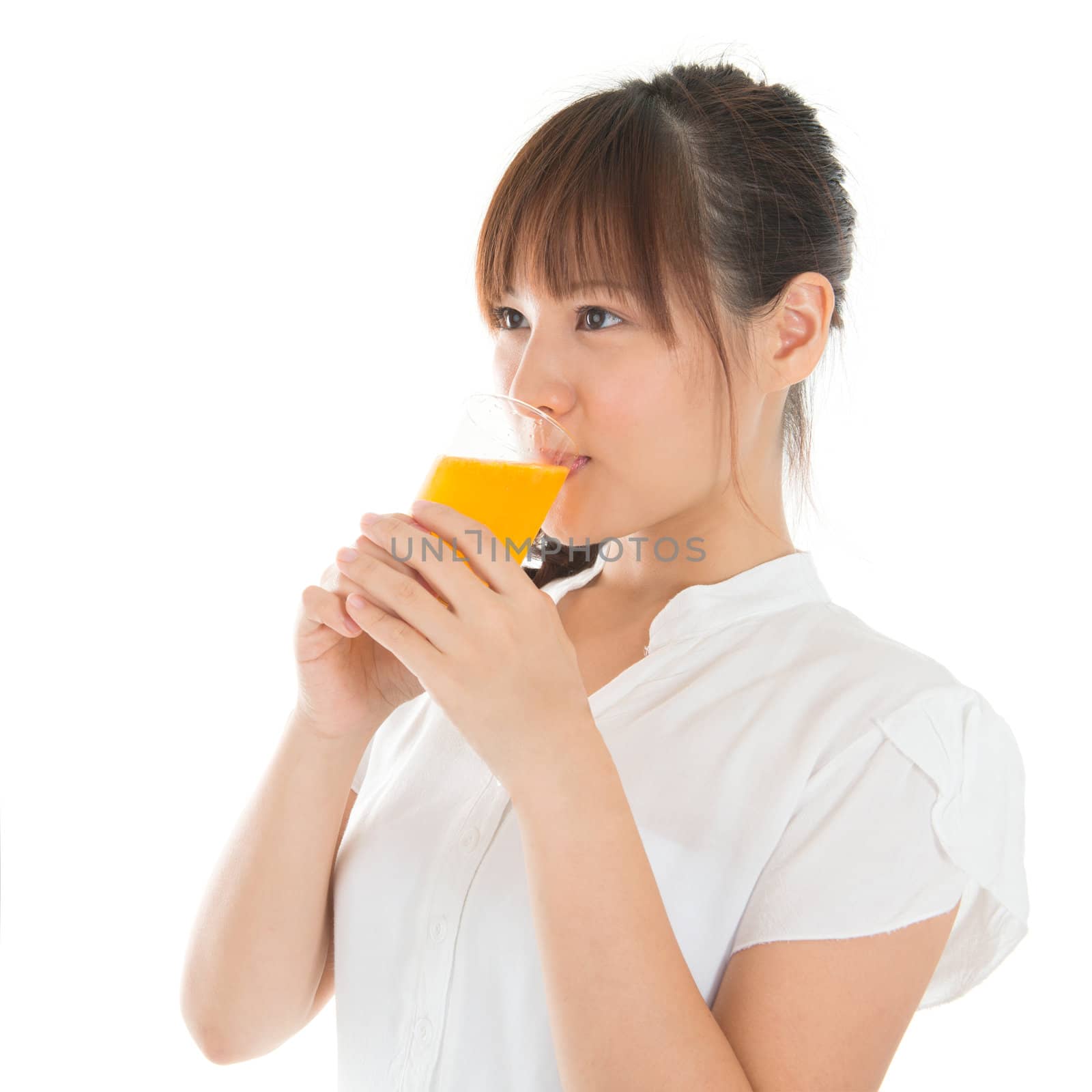 Young Asian woman drinking orange juice, isolated on white.