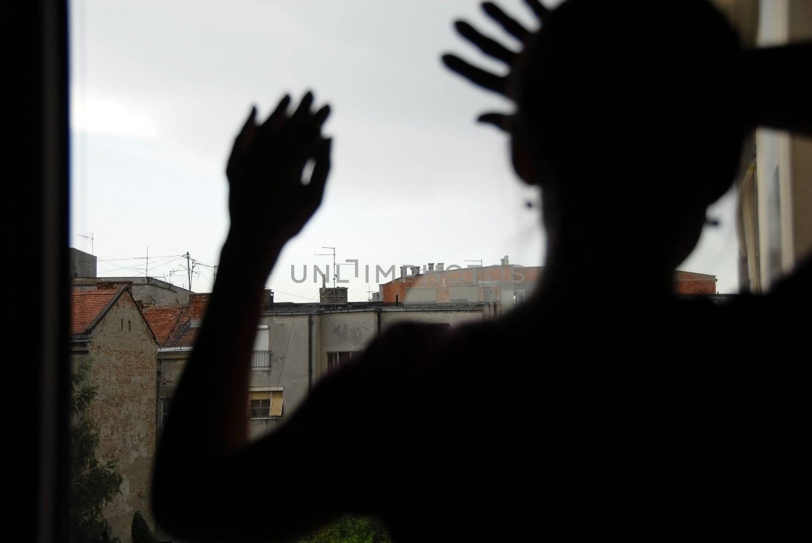 woman black silhouette looking out window indoors, with hands on glass