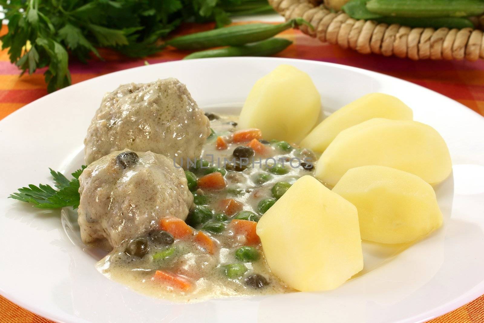 cooked meatballs in a white sauce with capers by silencefoto