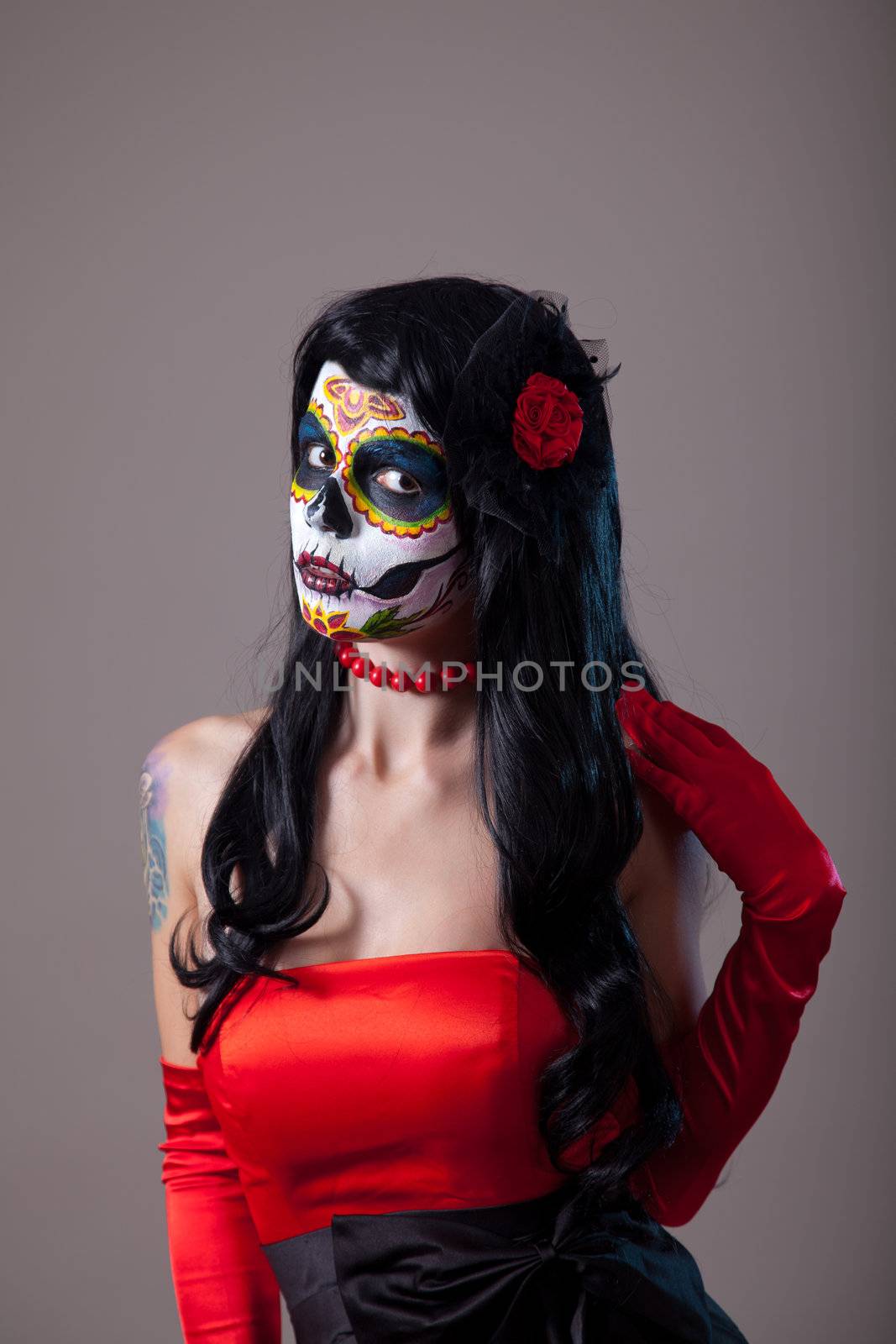 Woman with sugar skull make-up wearing red dress, the Day of the Dead 