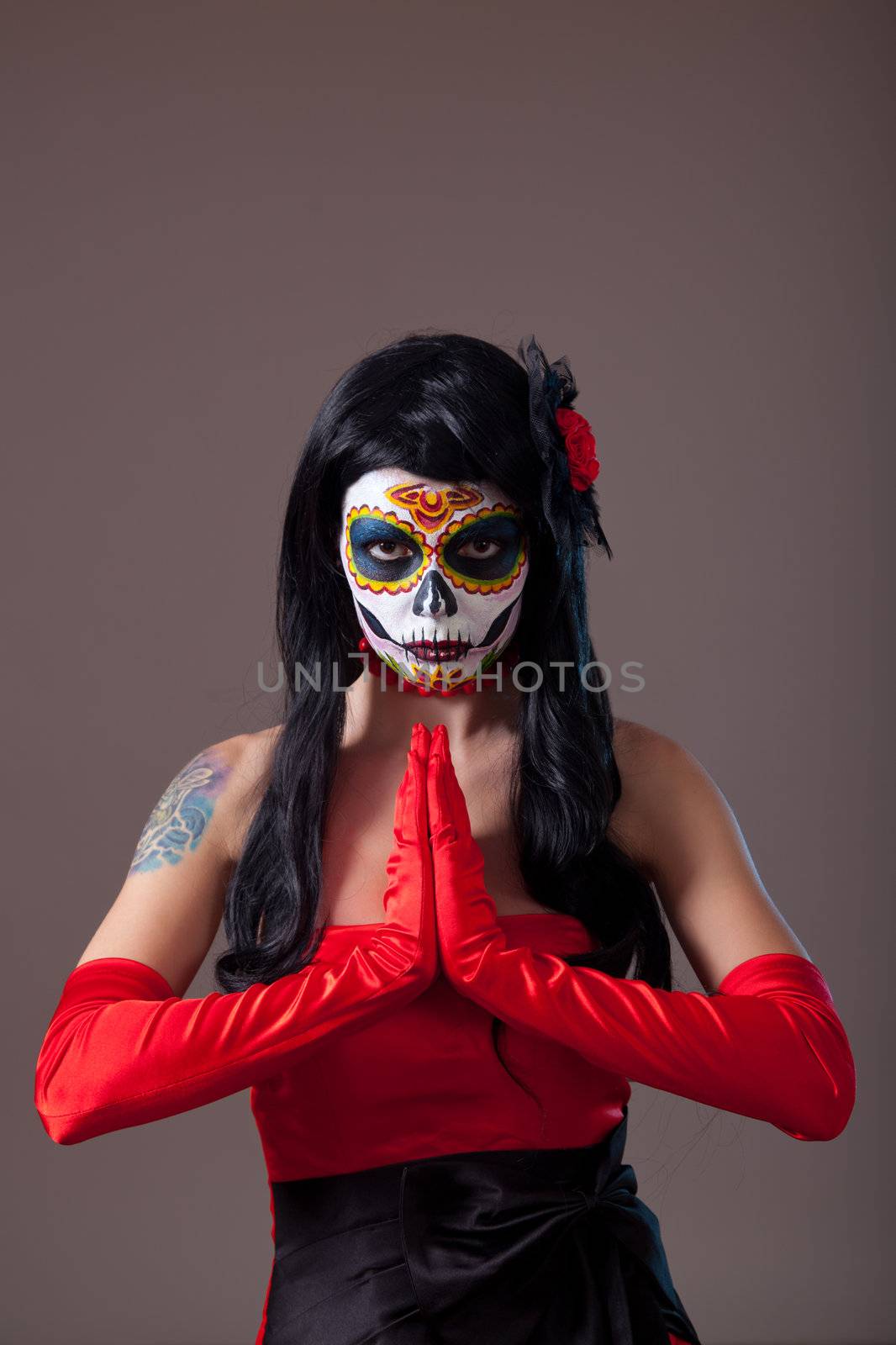 Praying woman with sugar skull make-up, the Day of the Dead 
