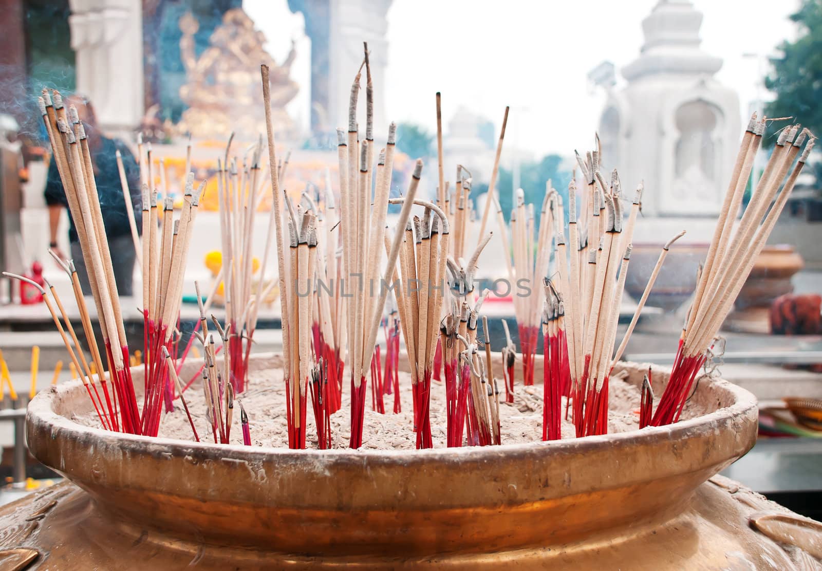 burning incense sticks in Brass Incense bowl at buddhist shrine