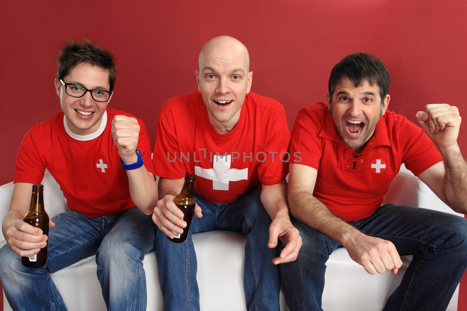 Photo of three male Swiss sports fans cheering for their team.