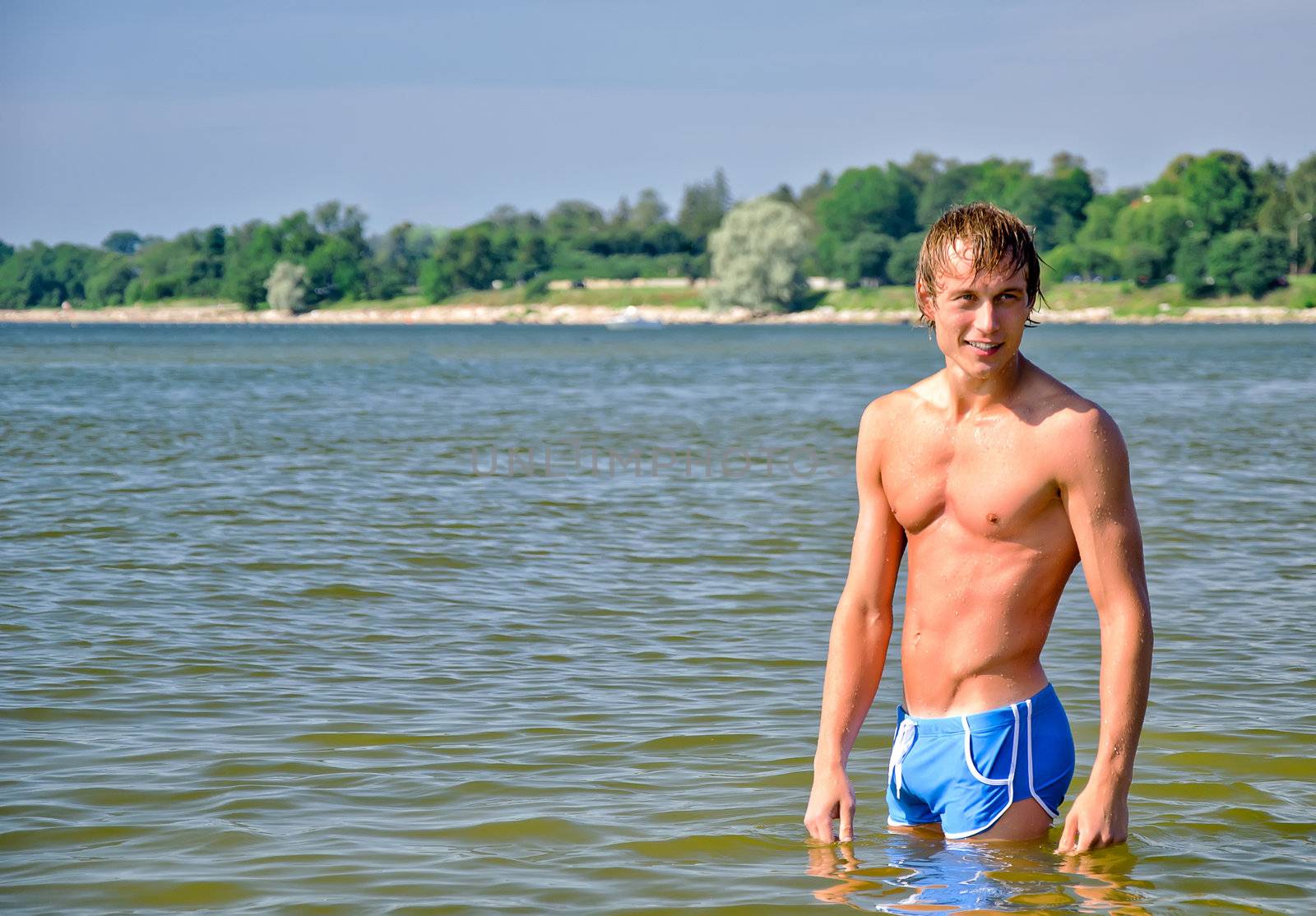 Semi nude handsome man standing in the sea