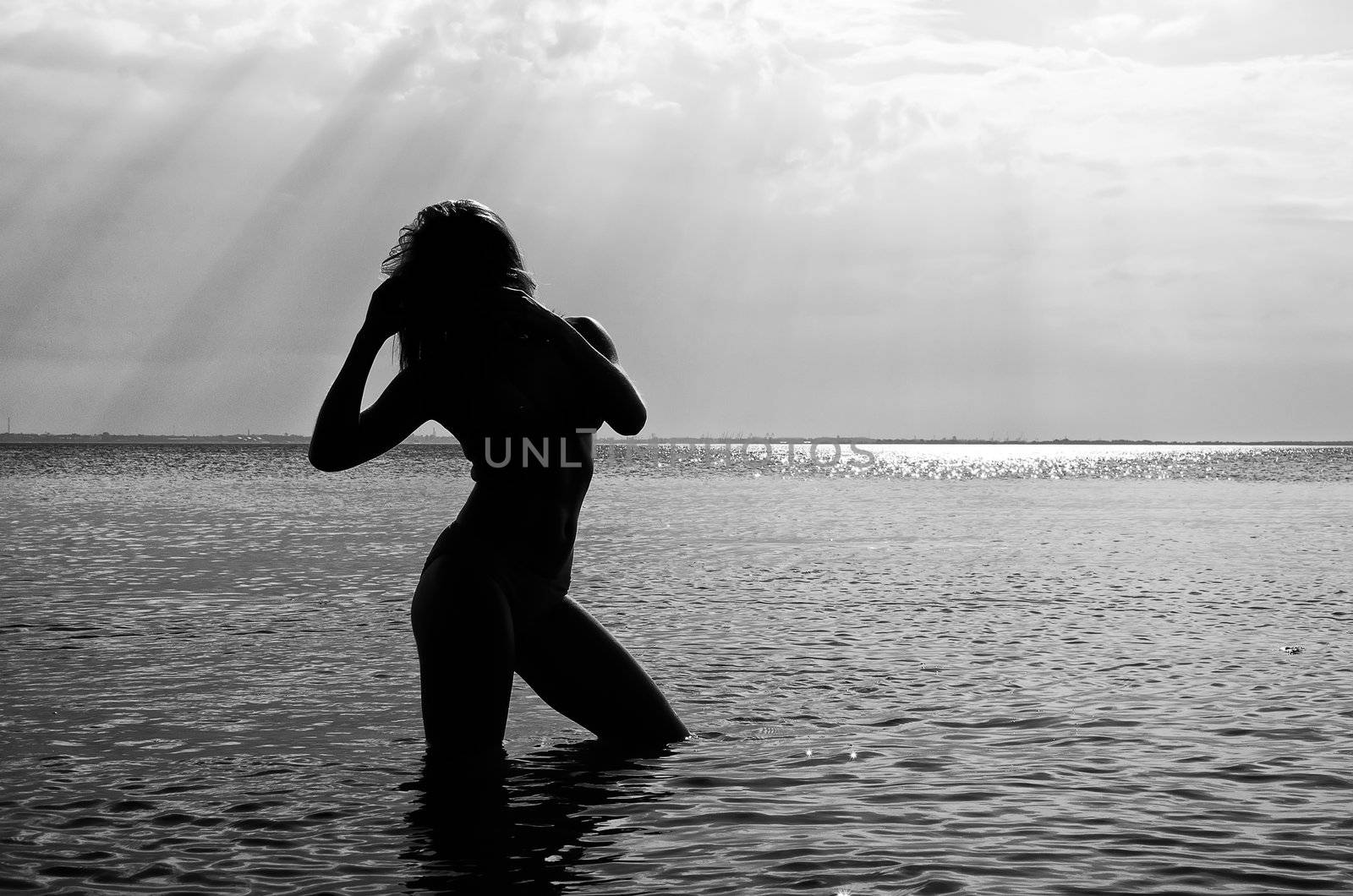 Black and white photo: Silhouette of woman in the sea