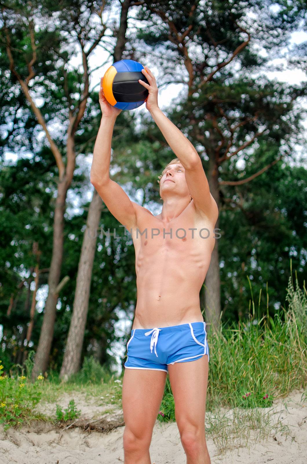 Young man playing volleyball on the beach