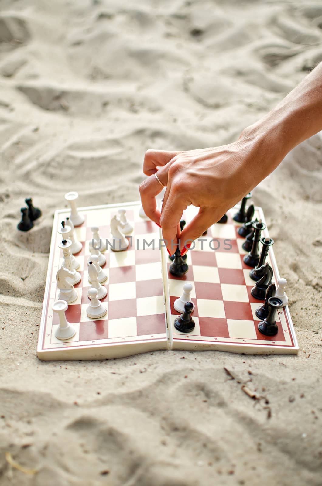 Image of human hand with chess figure making move
