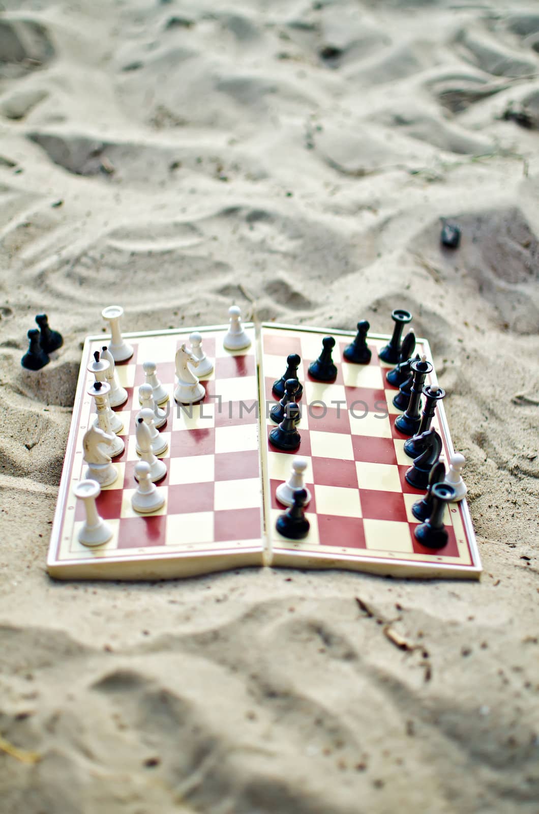 Chessboard with figures on it on the sand