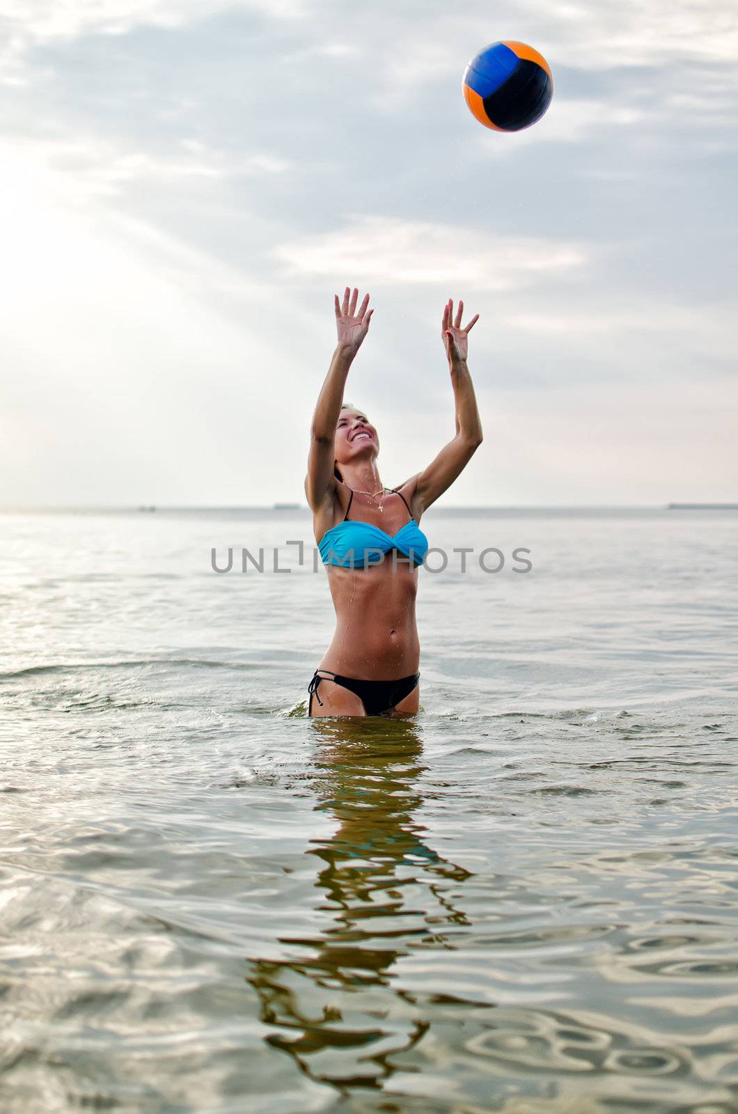 Young woman playing volleyball in the sea