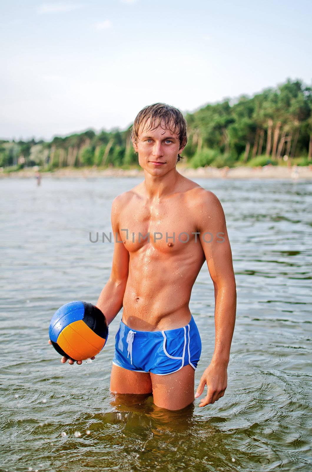 Young man posing with the ball in the sea