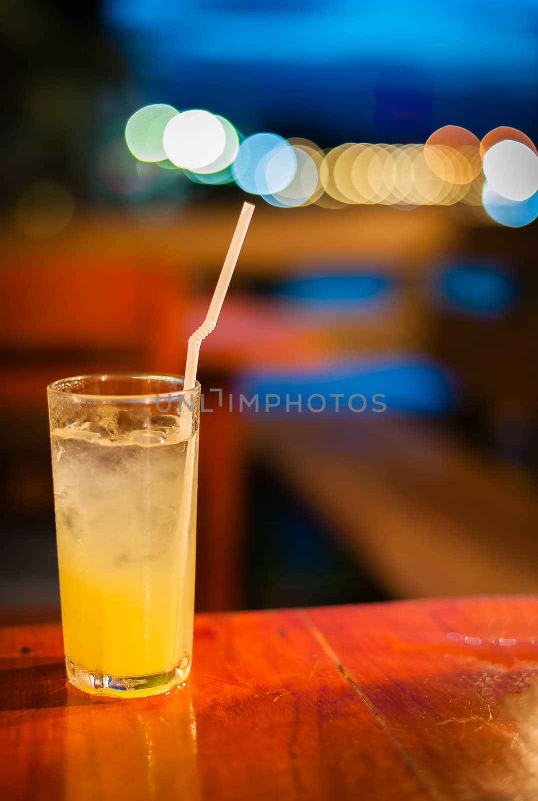 Orange juice on table wilth color of light in club