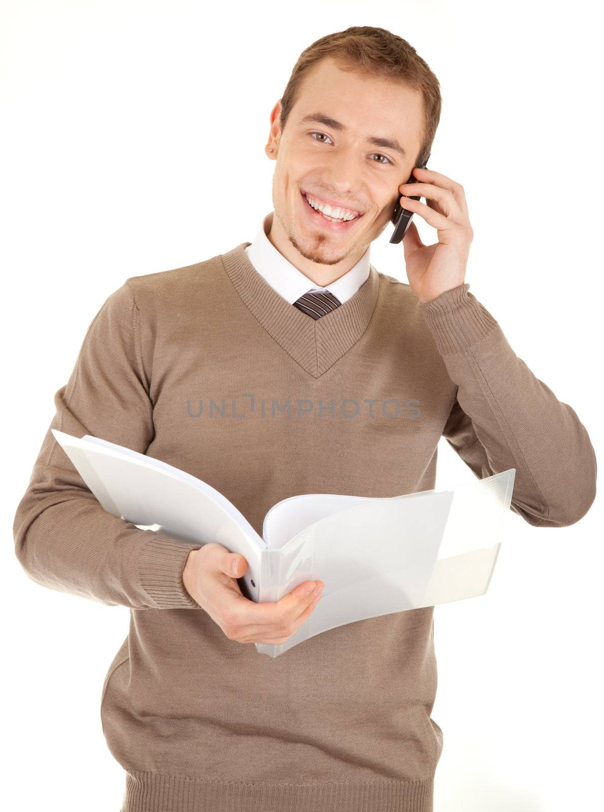 Young well-dressed man in formalwear is talking by phone and holding a open white file with documents. Isolated on white background.