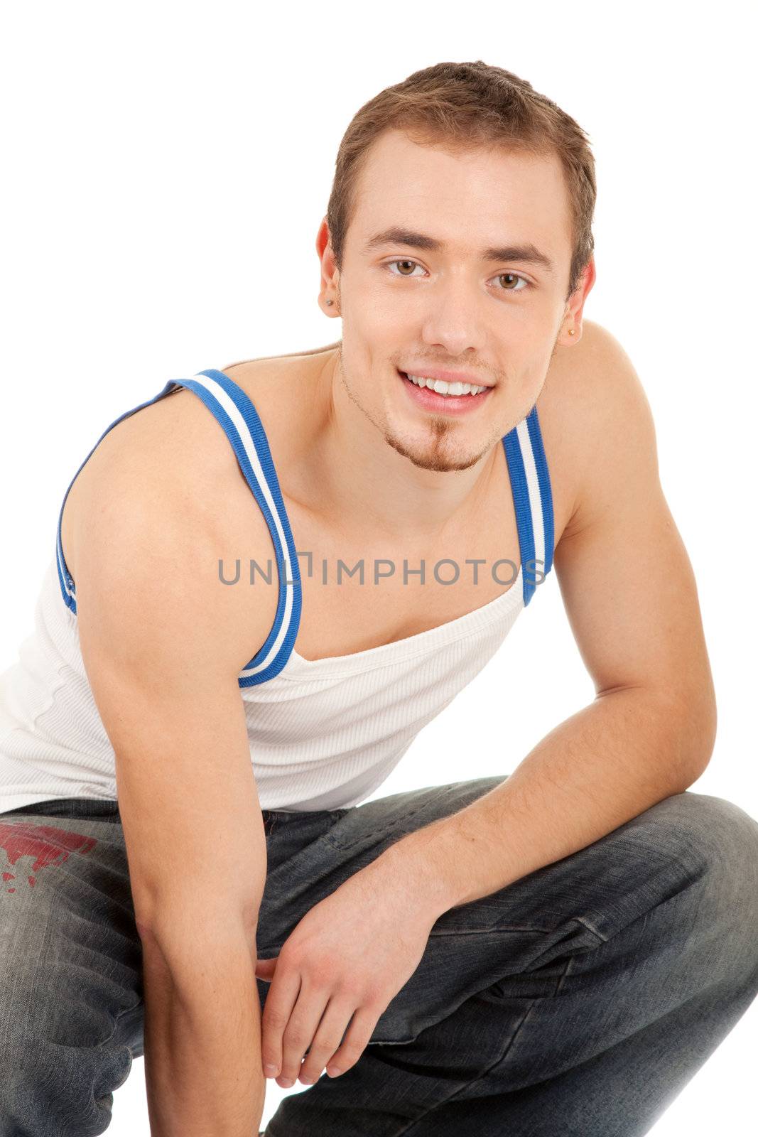 Handsome young man in T-shirt and jeans is looking to you. Isolated on white background