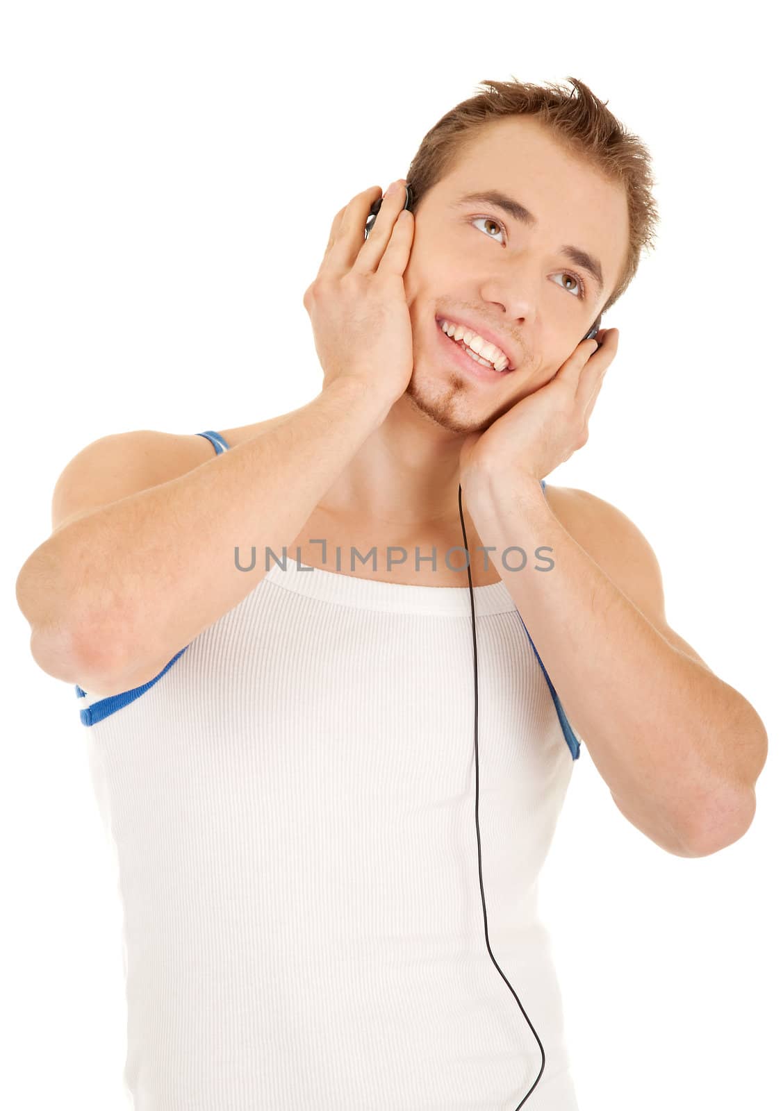 Smiling handsome young man in casual style with headphones is listening music, isolated on white background