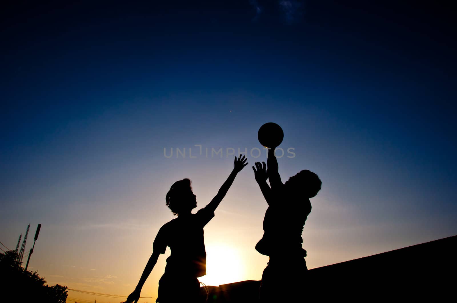 silhouette of man playing basketball