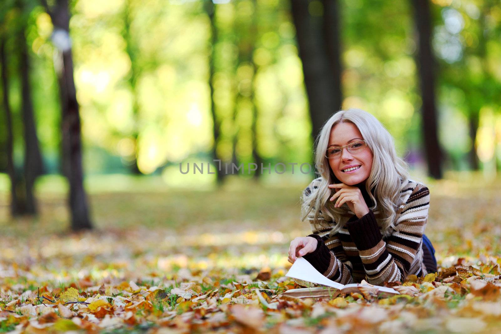 woman read the book in autumn park