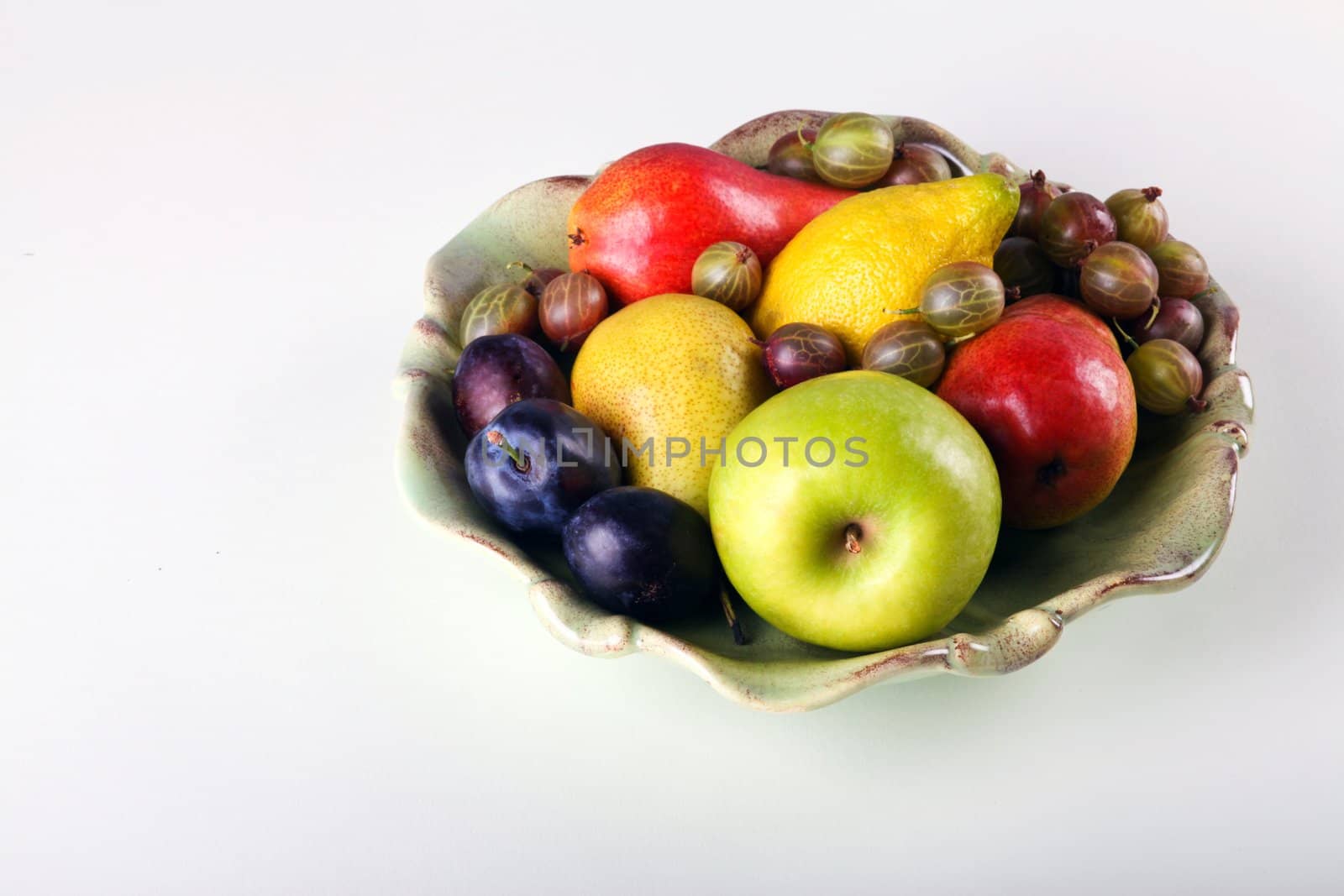 Fresh fruits  in ceramic plate on white background