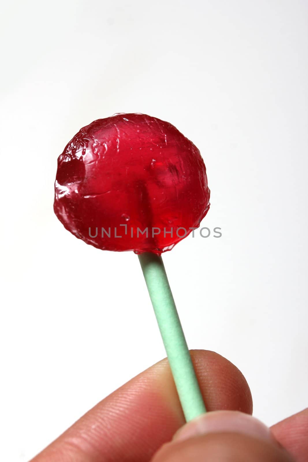 red lollipop in a human hand