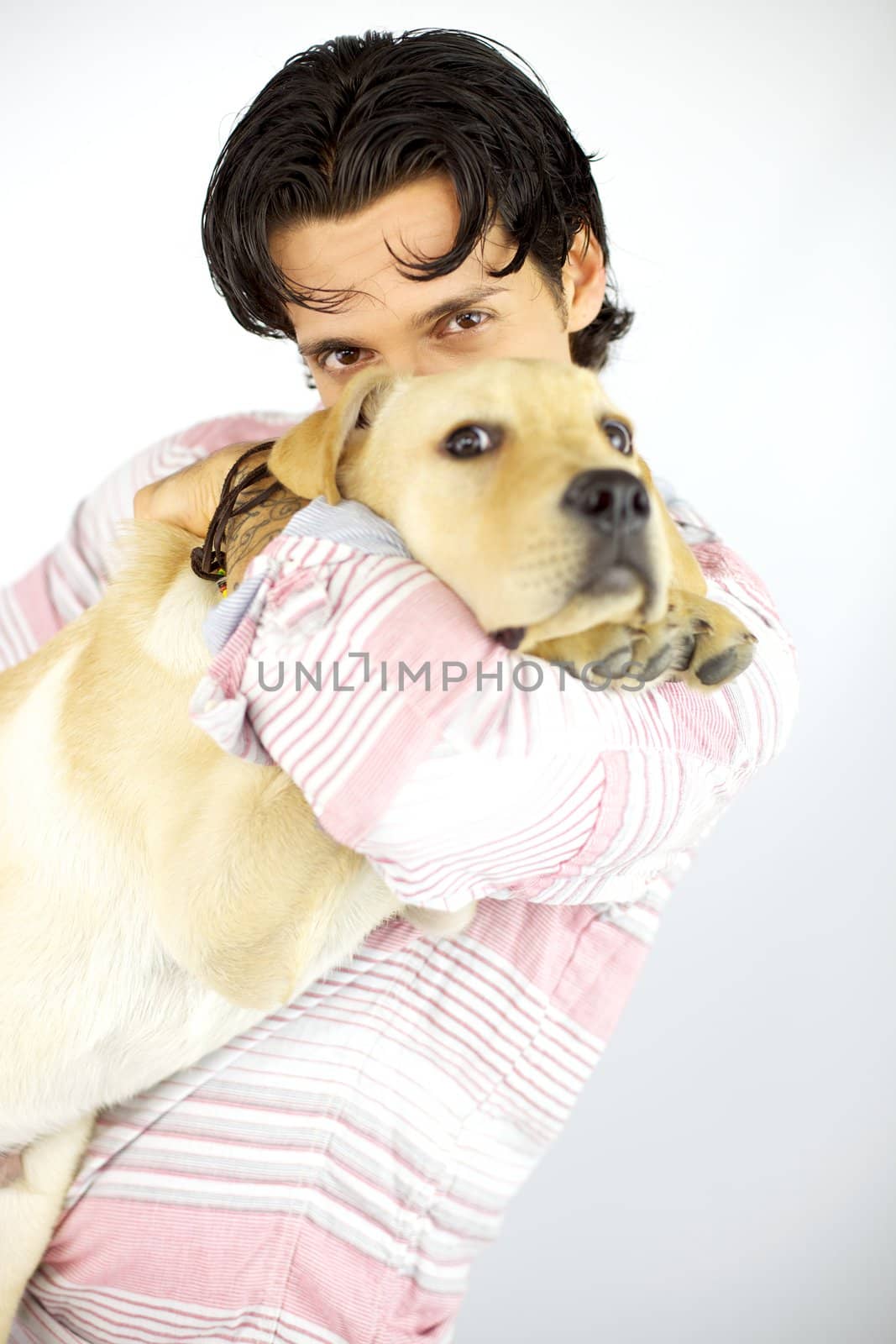 Young man kissing his puppy dog labrador by fmarsicano