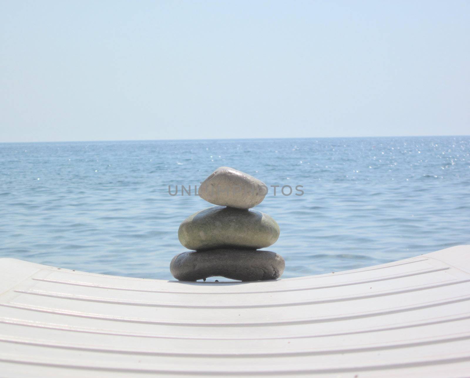 The stack of pebble stones in zen concept  on chaise longues 