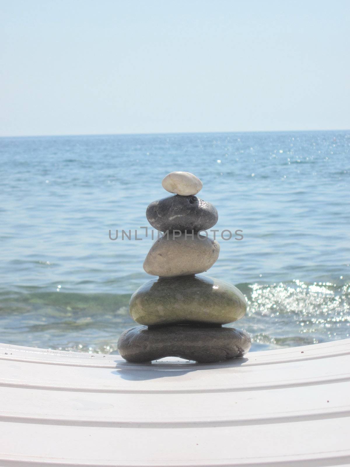 The stack of pebble stones in zen concept  on chaise longues  by svtrotof