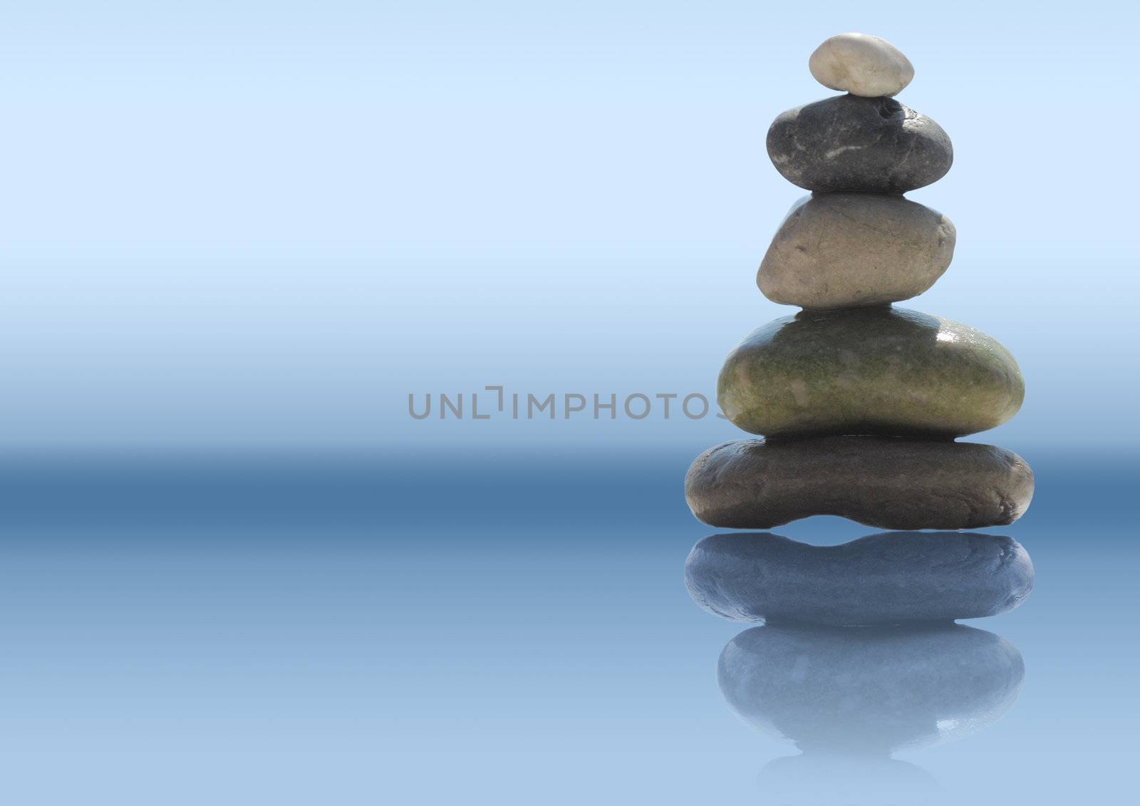 The stack of pebble stones in zen concept on blue