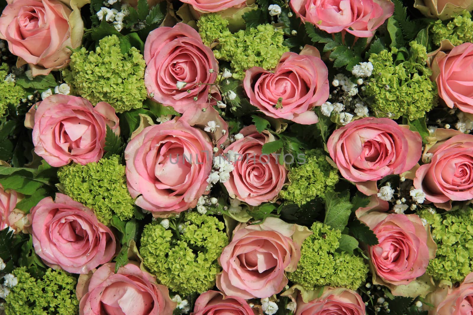 Small pink roses and white gypsophila in a wedding centerpiece