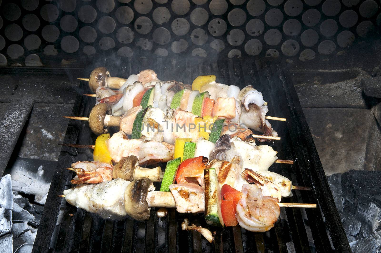cooking skewers of seafood in a restaurant