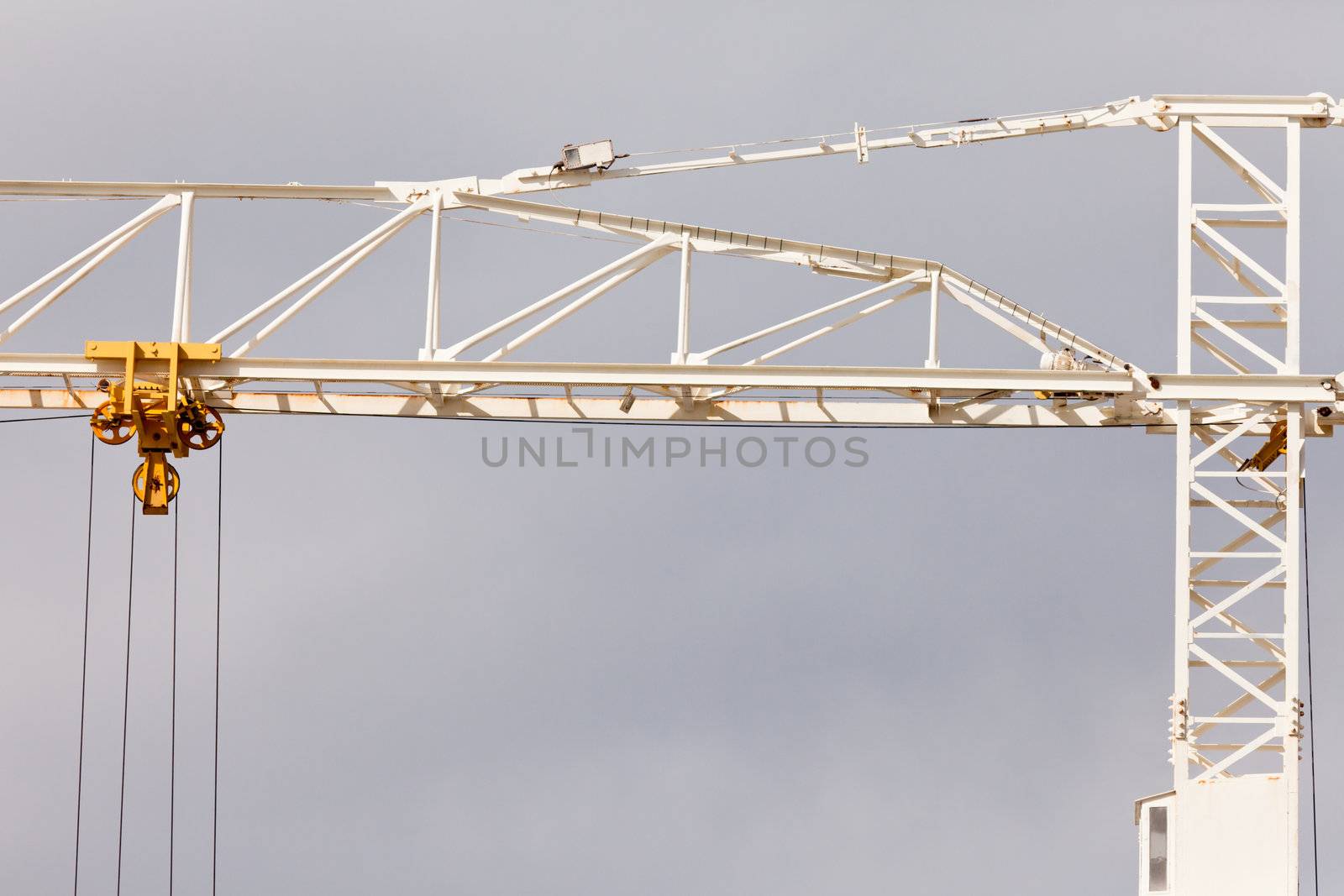 Detail abstract of old rusty steel construction crane for hoisting heavy loads during building construction and development
