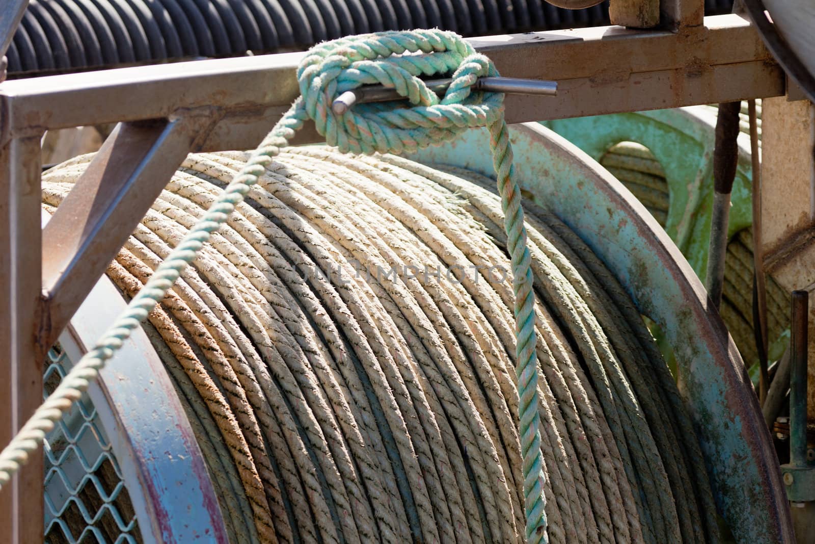 Closeup of drum of old worn hemp rope coils on fishing boat deck