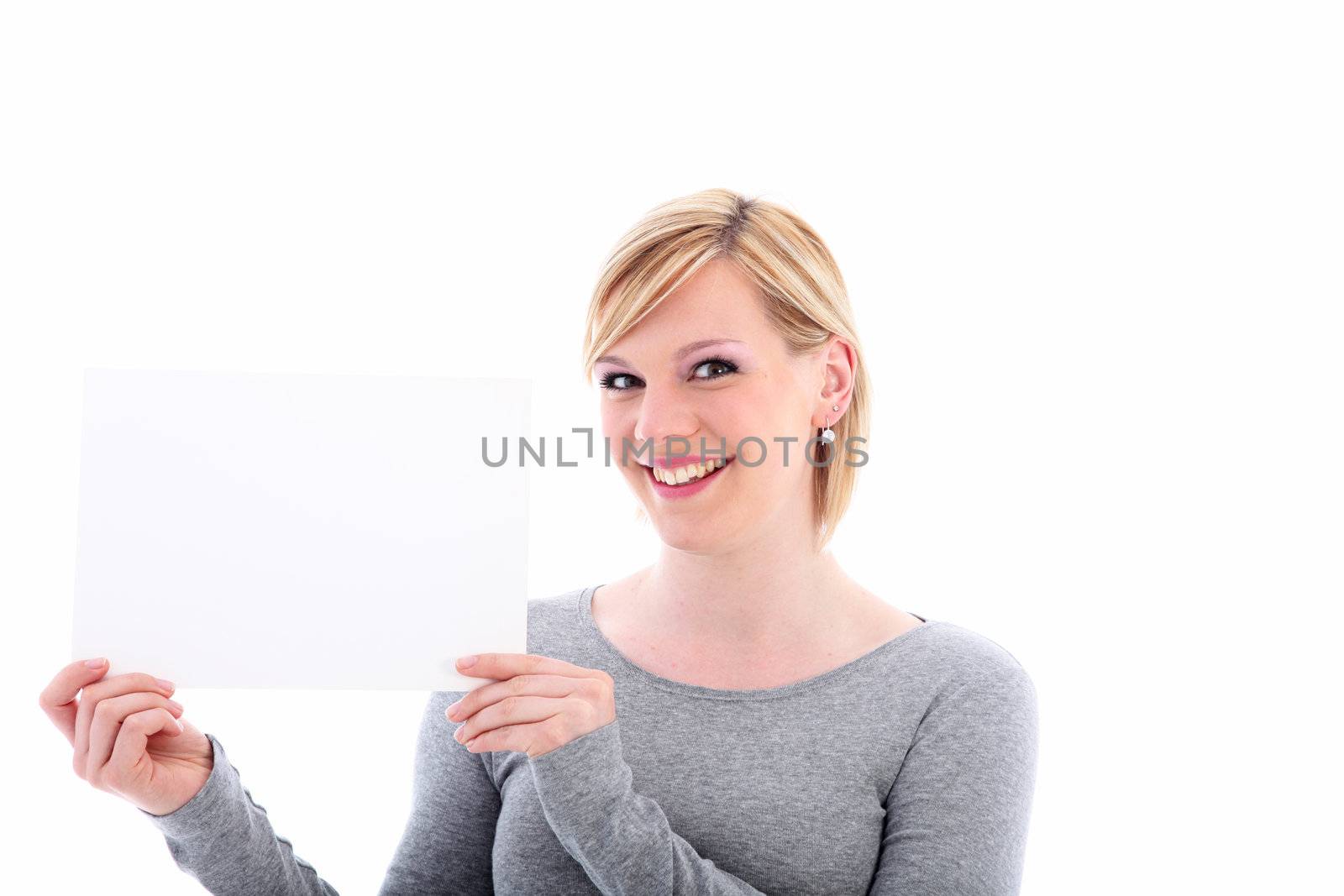 Smiling young woman holding a blank white sign for your text to the side of her face isolated on white 