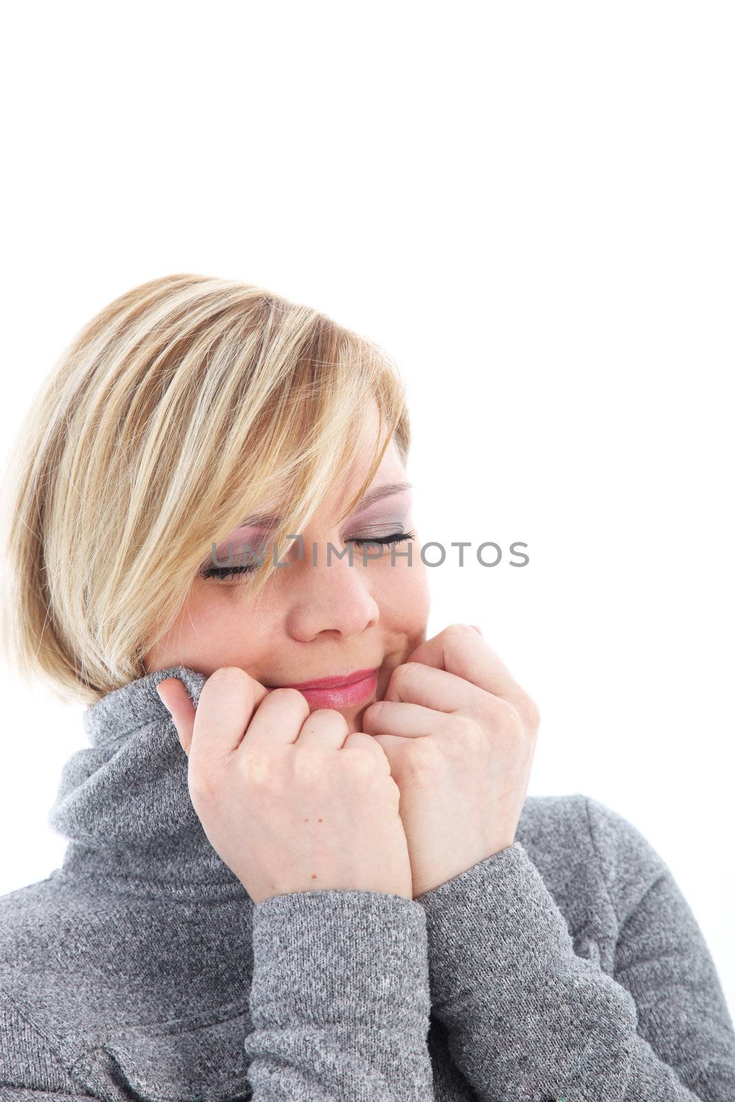 Cold woman pulling the collar of her warm jacket high around her cheeks suffering with freezing winter temperatures 