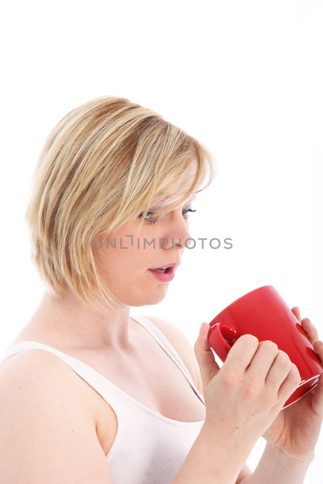 Woman looking with dismay at the bottom of her empty coffee mug isolated on white 