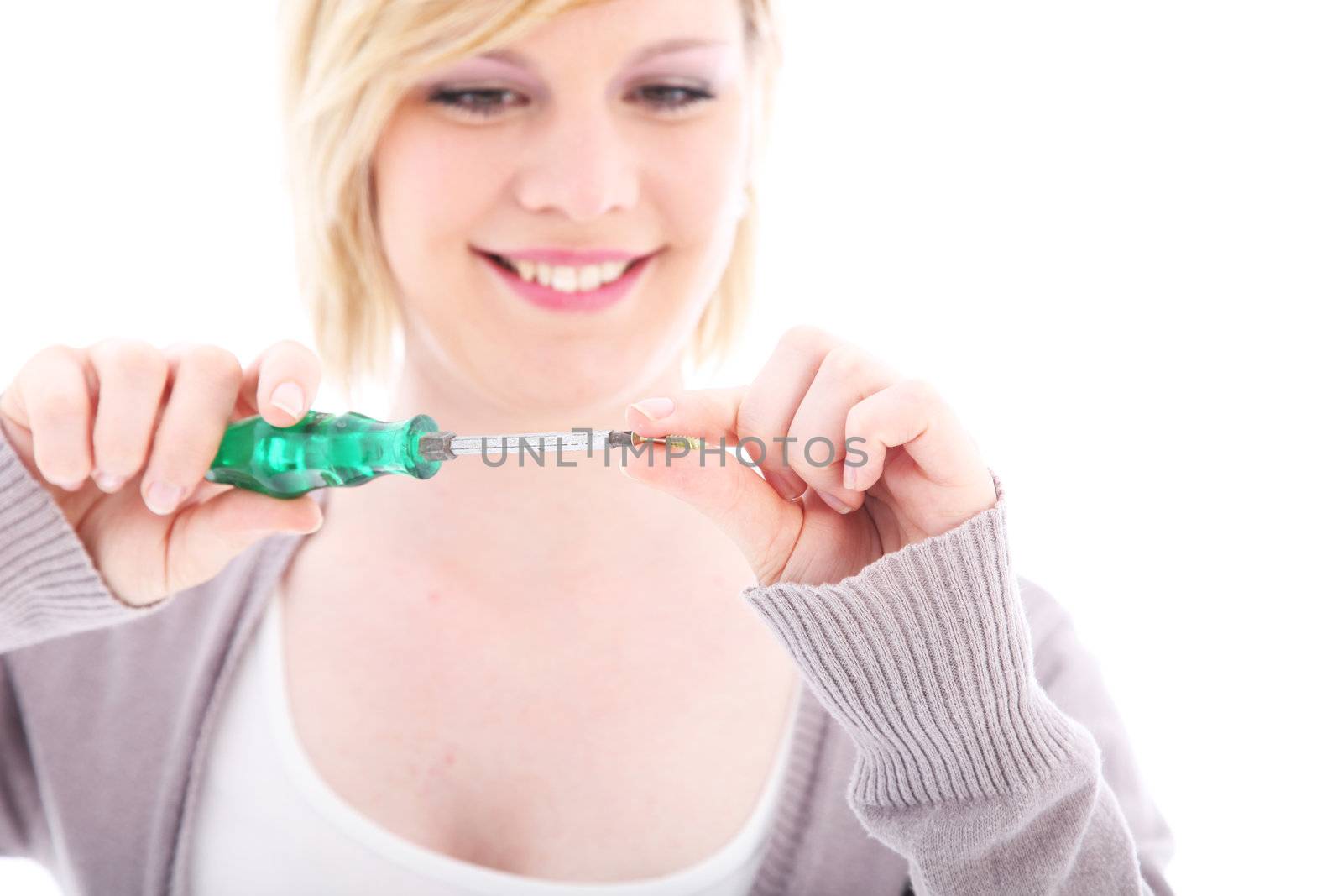 Competent smiling woman doing DIY working with a screwdriver and screw isolated on white 