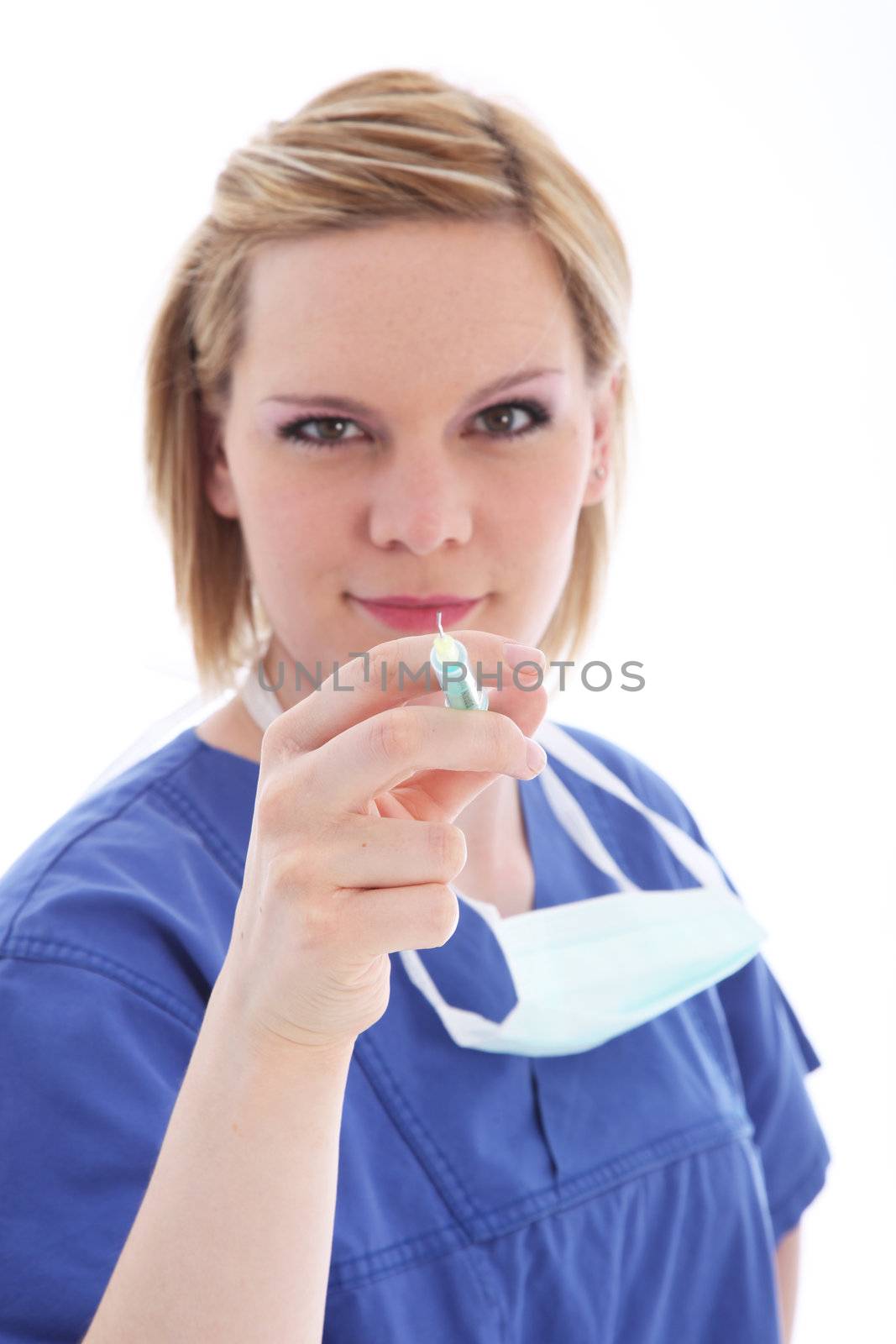 Nurse in blue scrubs standing holding the hypodermic and needle ready to administer an injection 
