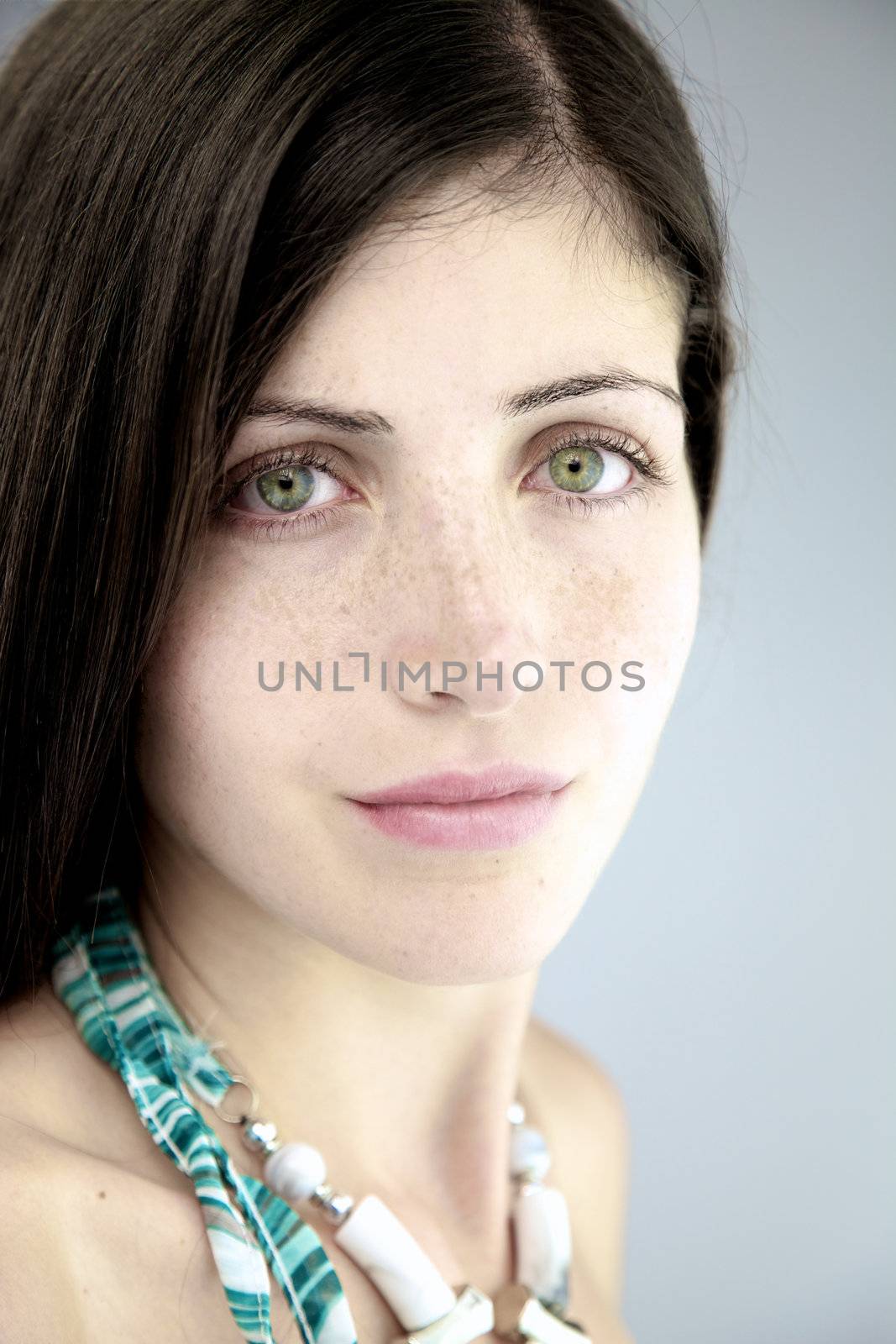 Sexy female model closeup posing serious with beautiful green eyes and freckles