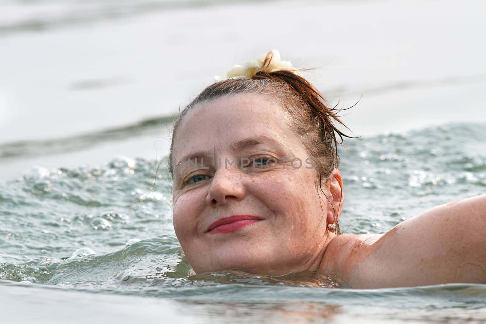 Smiling woman swimming in the water