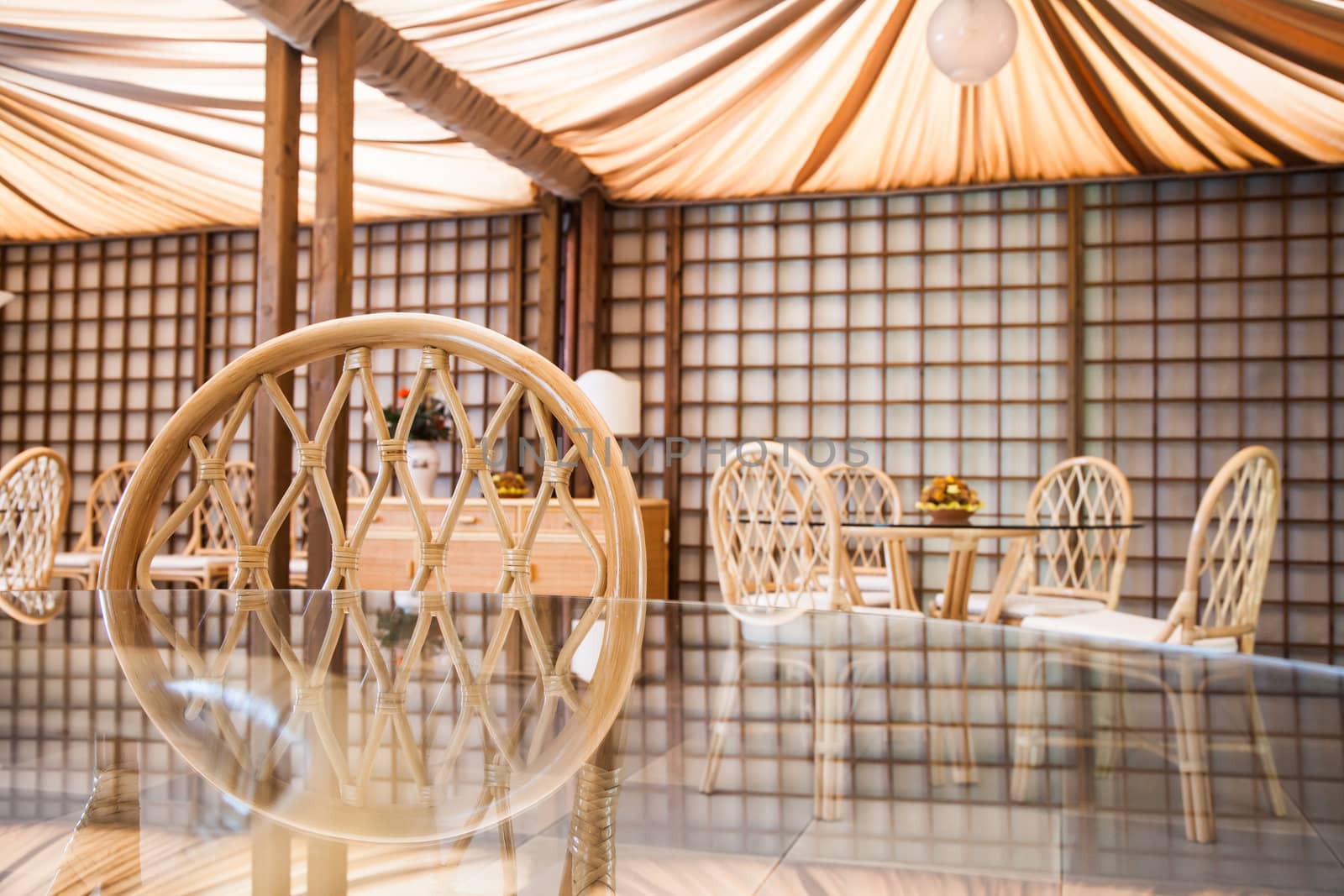 Glass table with wickler chairs in an elegant interior