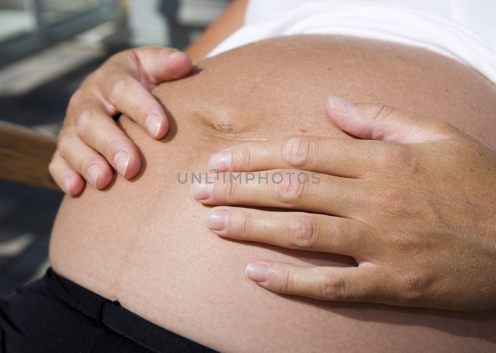 Pregnant woman holding her hands on the stomach