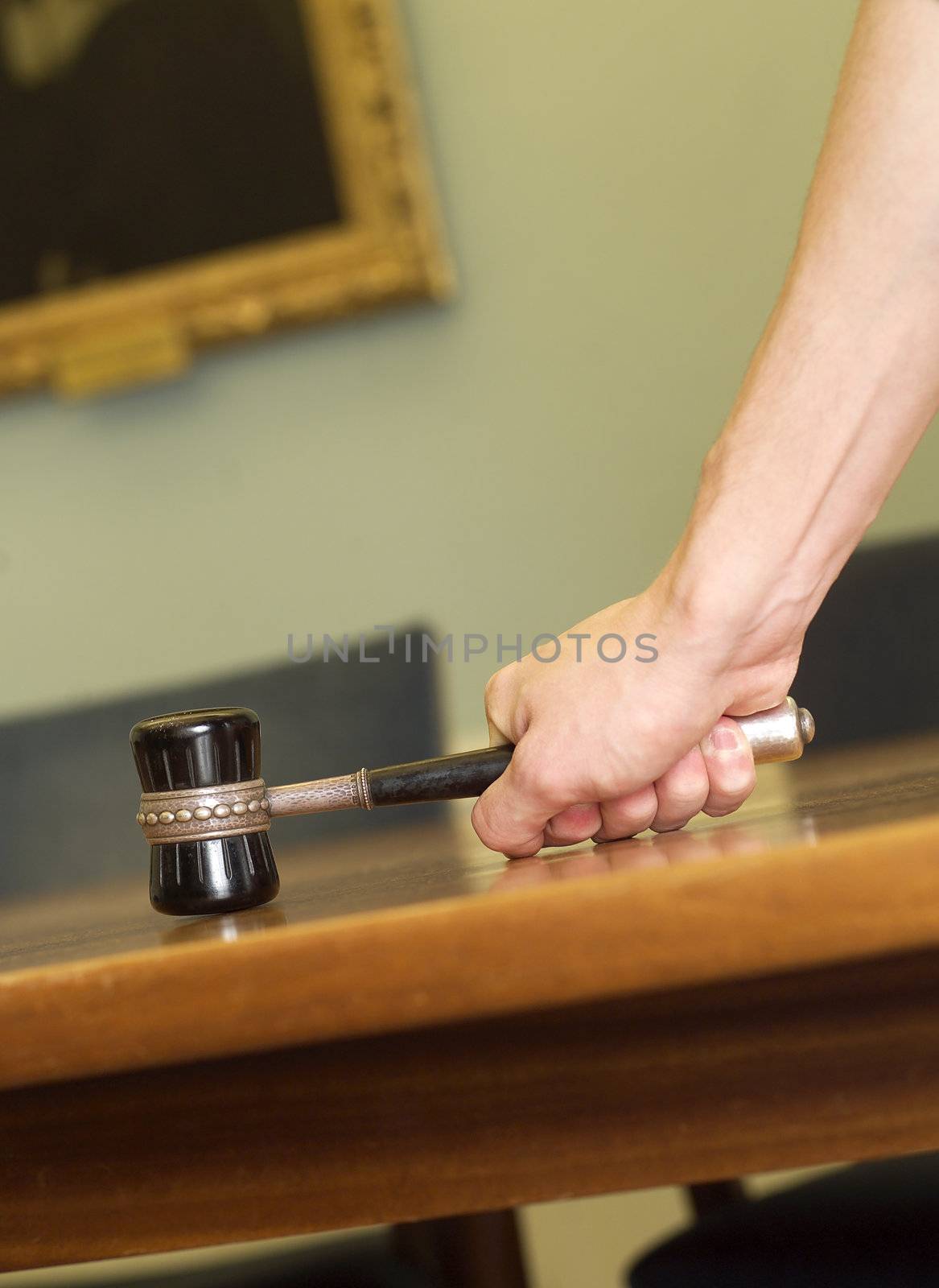 Hand Holding a Mallet on a table