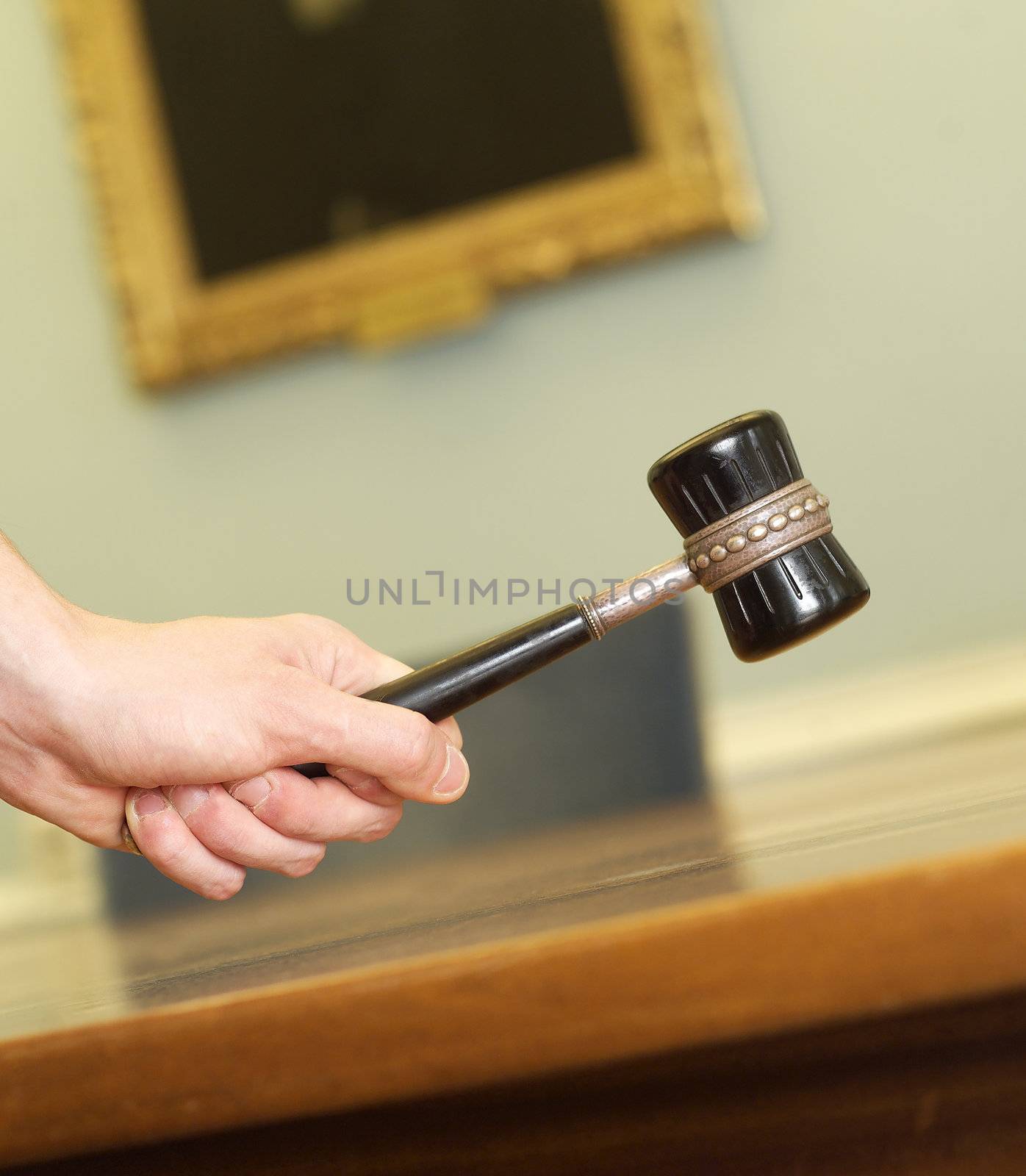 Hand Holding a Mallet on a table