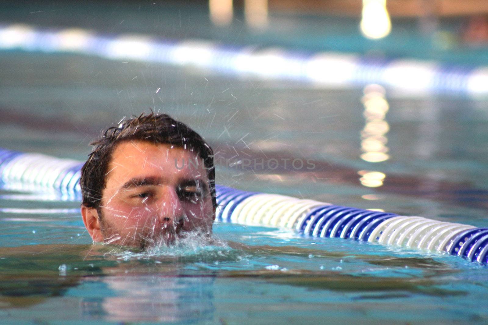 man swims in swimming pool