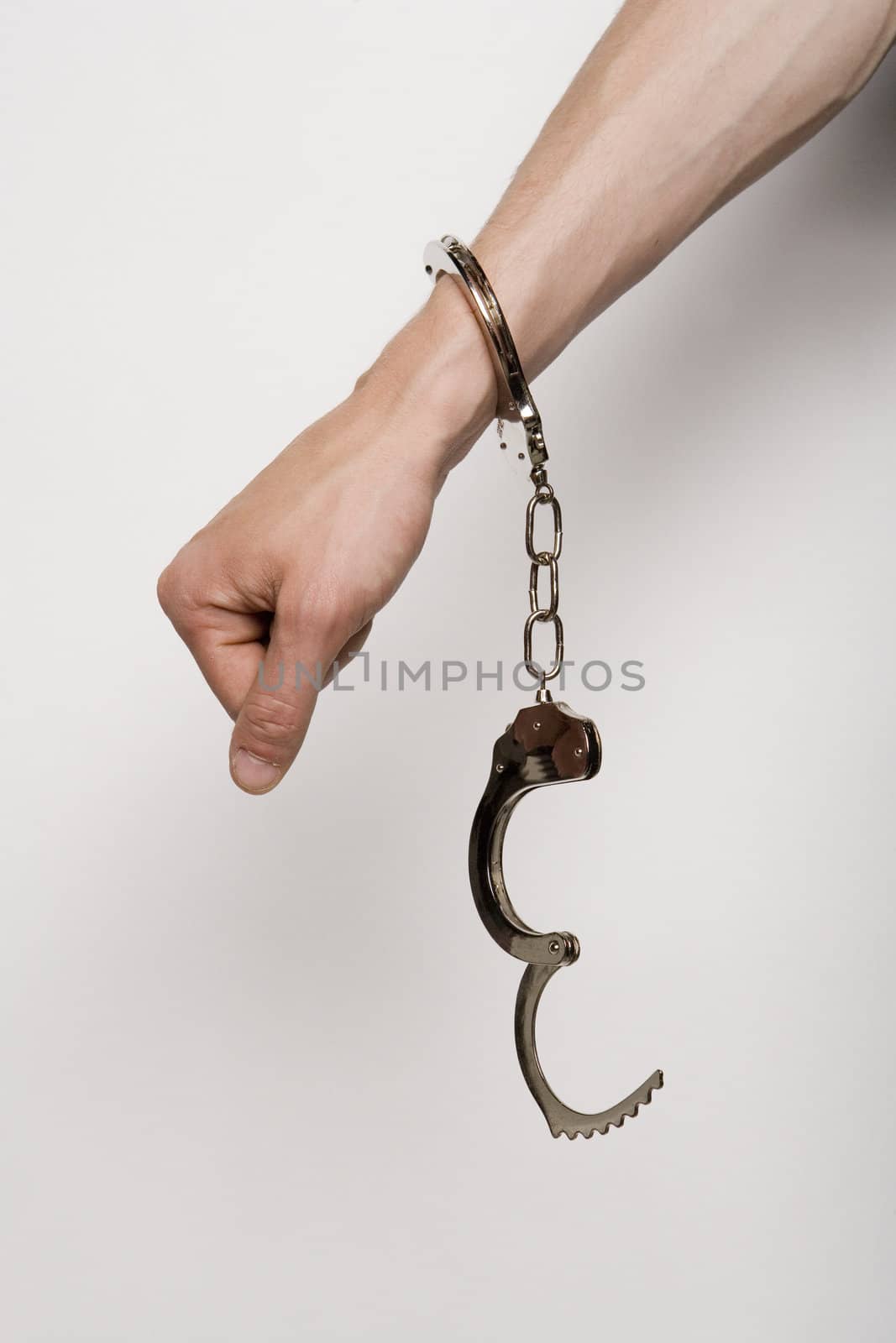 Unreconizable teenager with handcuffs on grey background