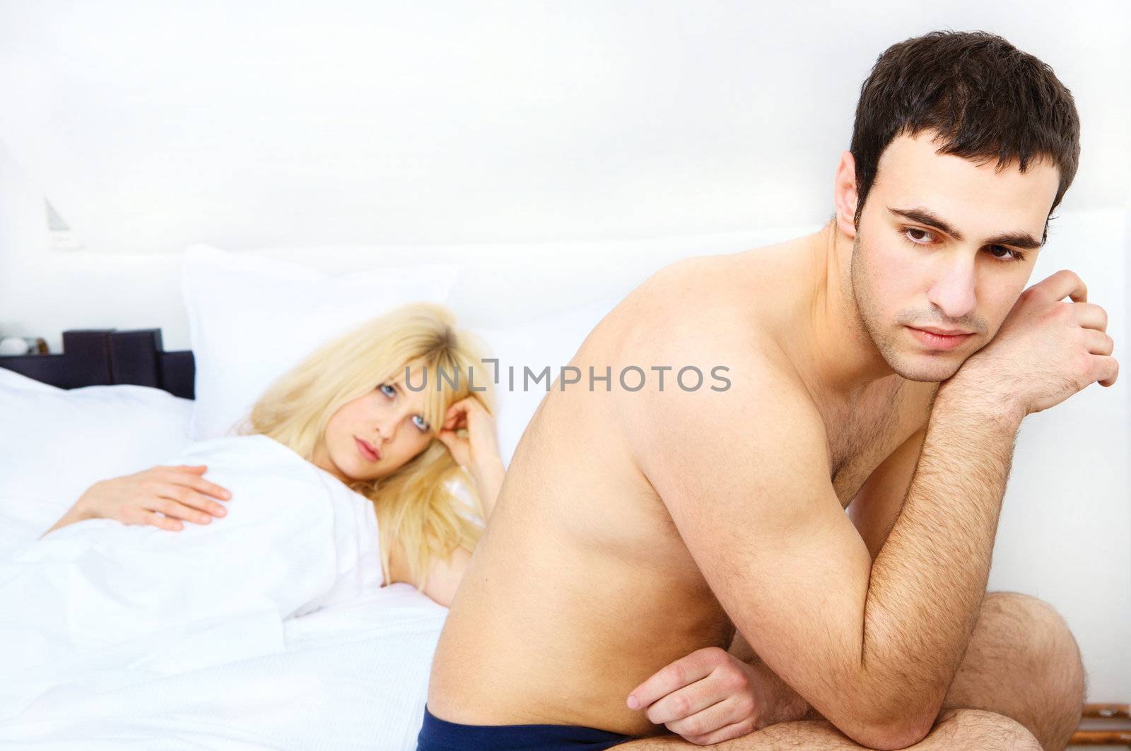 relationship of a unhappy young couple in bedroom, focus on male