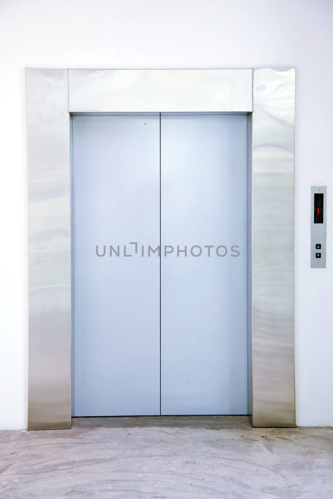 Front view of a modern elevator with closed doors in lobby